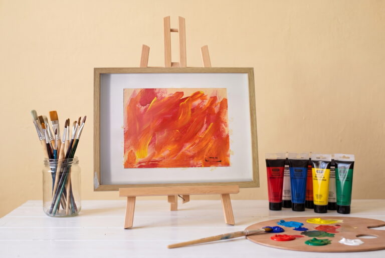 Feu dansant, peinture acrylique rouge et orange en mouvement, Mimie BB, posée sur un chevalet